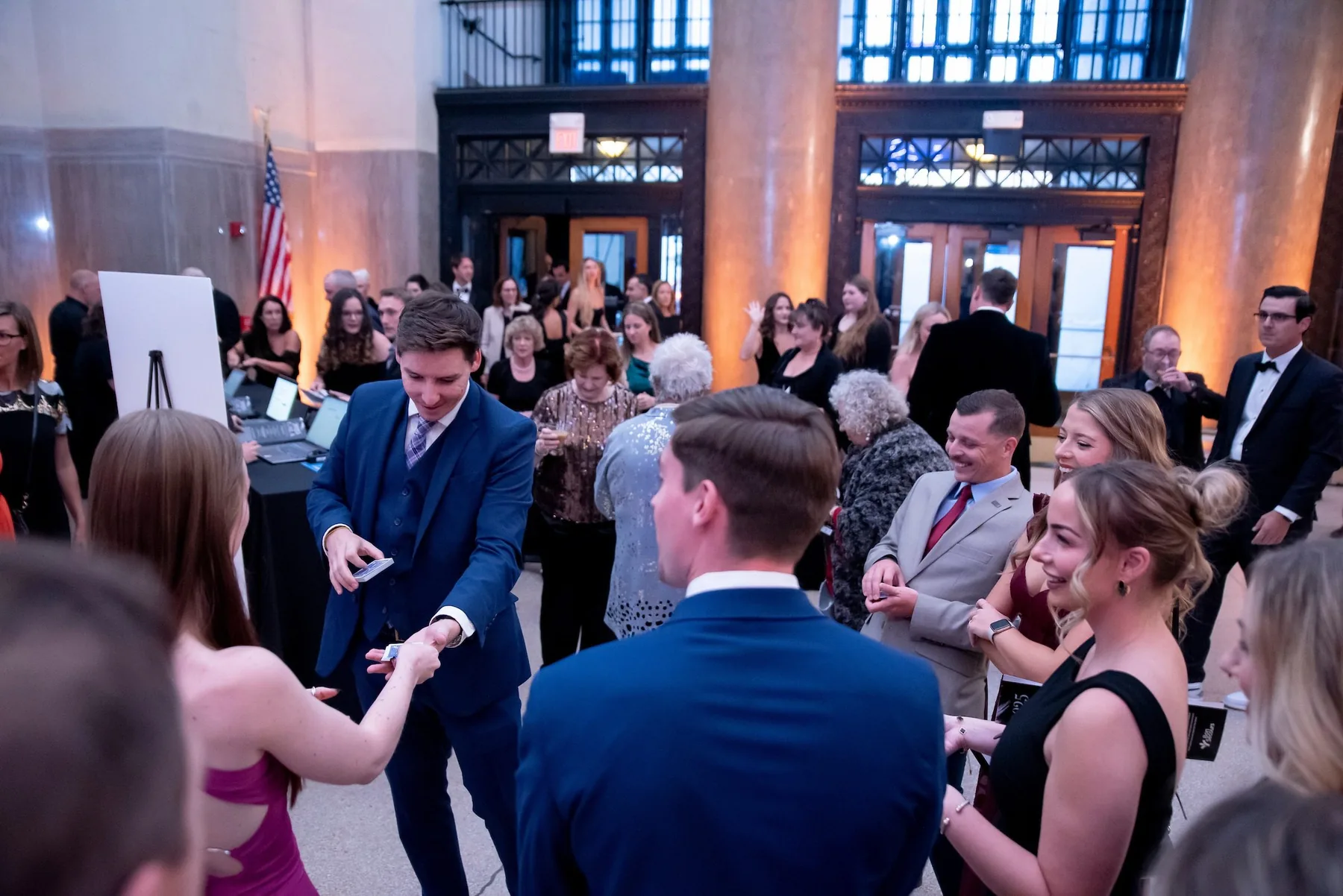 Guests reacting as Michael Bloemeke performs mingling magic at a gala