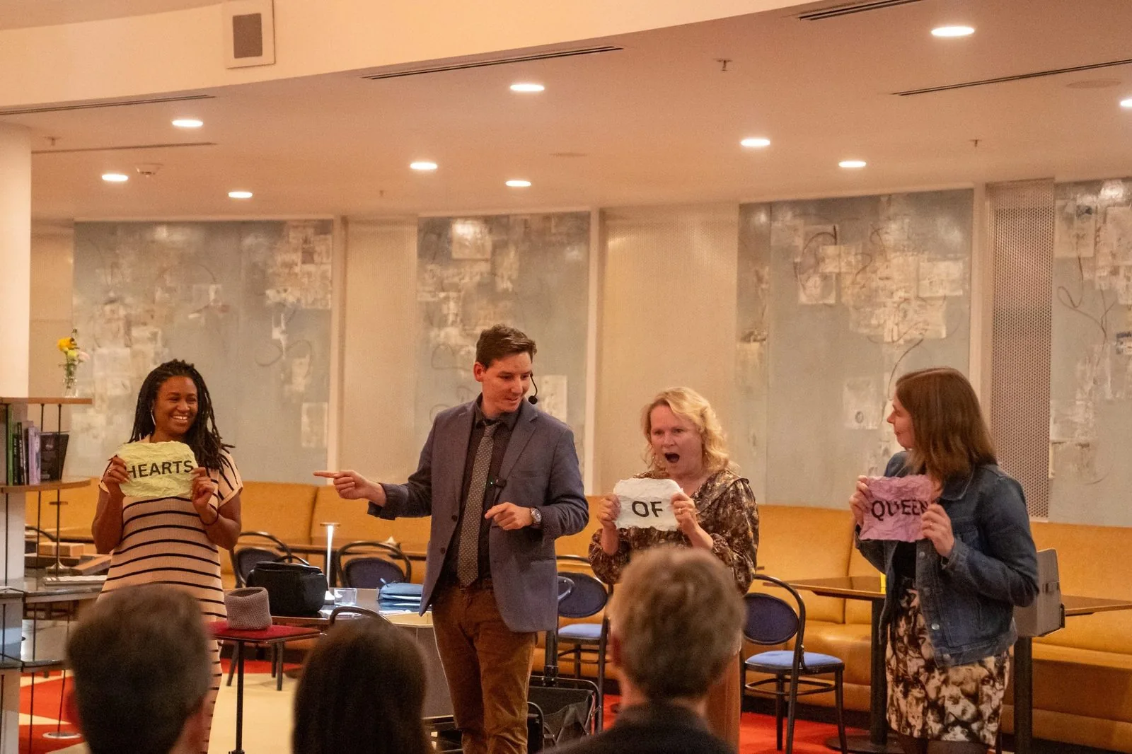 Michael Bloemeke performing a mentalism routine on stage with three audience volunteers