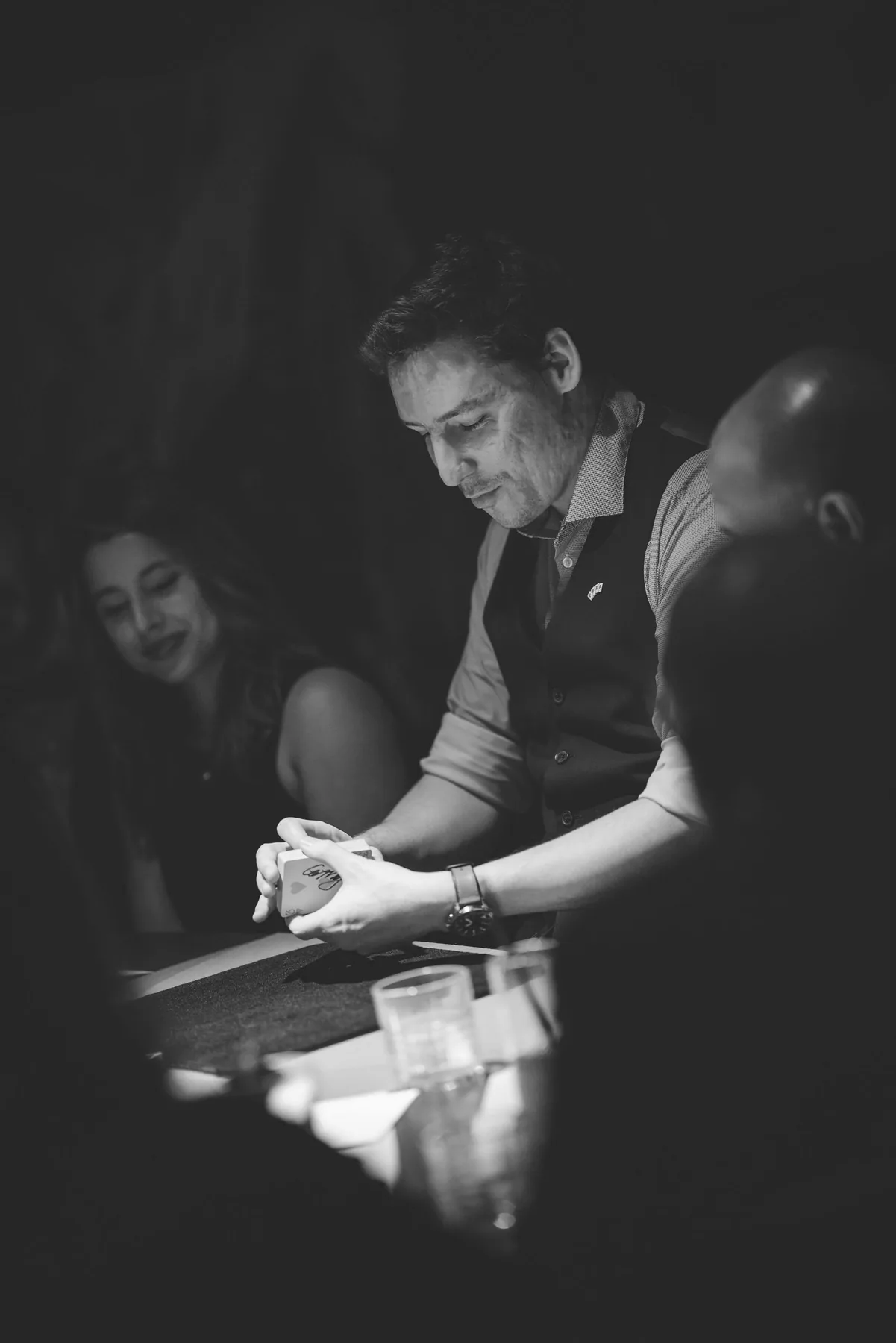 Michael Bloemeke performing close-up card magic at an intimate table, black and white